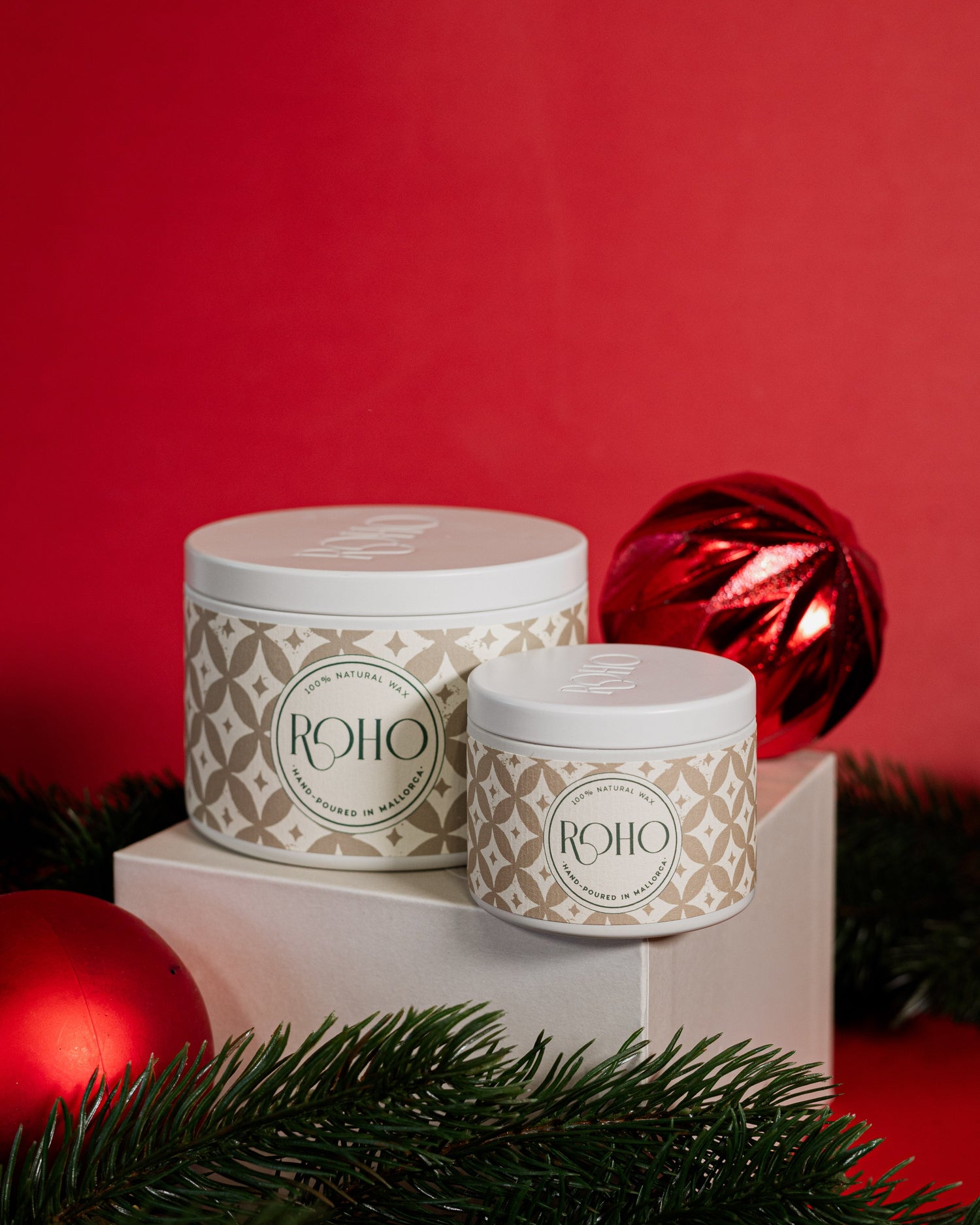 Two scented candles in beige patterned containers with &